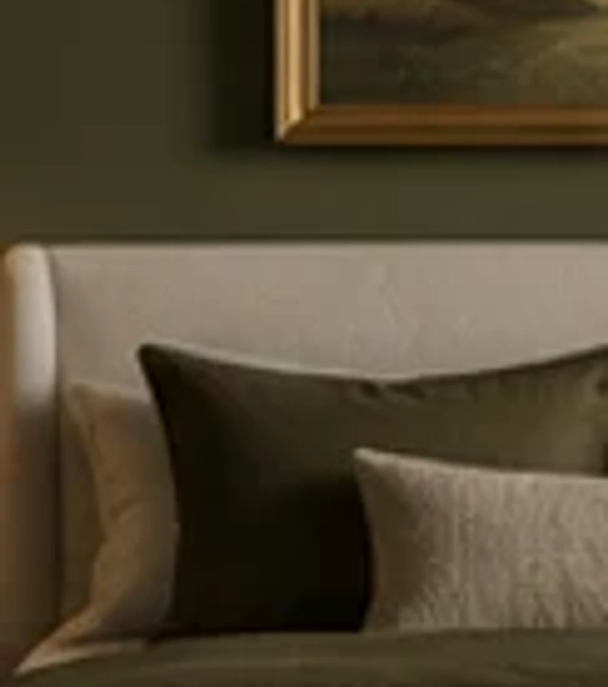 Olive bedroom with brass lighting and soft natural materials.