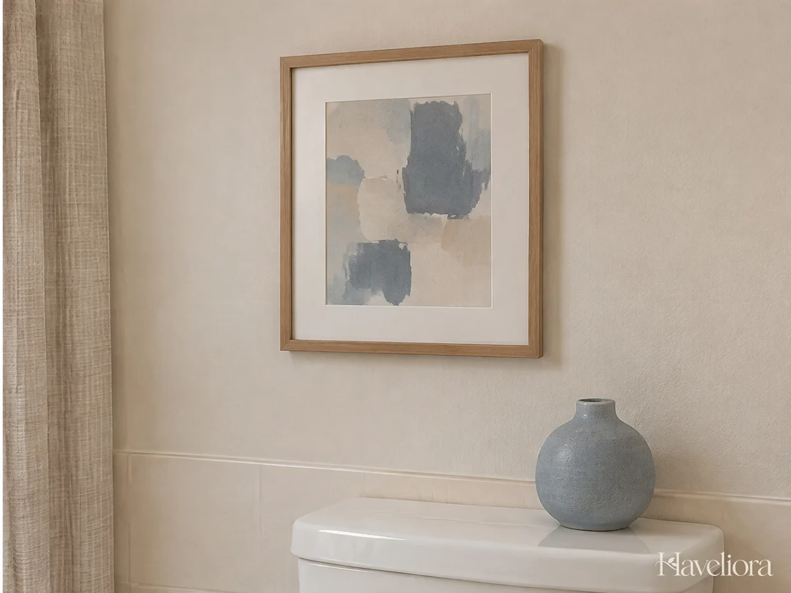 A small framed abstract artwork and one simple decorative object on a dry bathroom wall area.